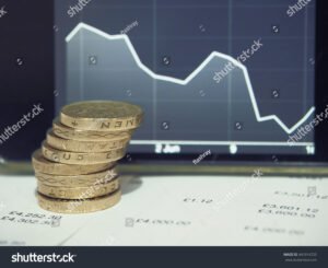 bilancia tra monete e grafico finanziario