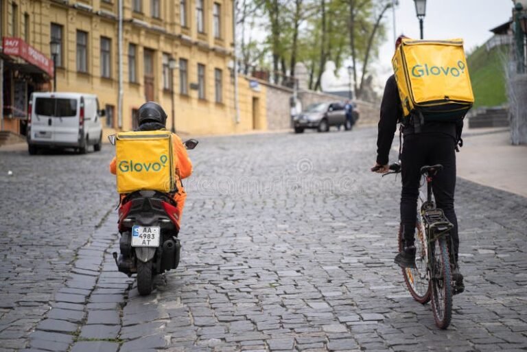 corriere glovo in bicicletta con zaino giallo