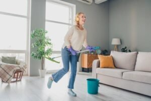 donna sorridente che pulisce una casa accogliente